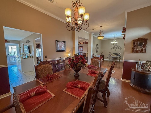 5020 Lantana Dr, Gulf Breeze, FL 32563 - dining area featuring a chandelier, crown molding, wood finished floors, and baseboards
