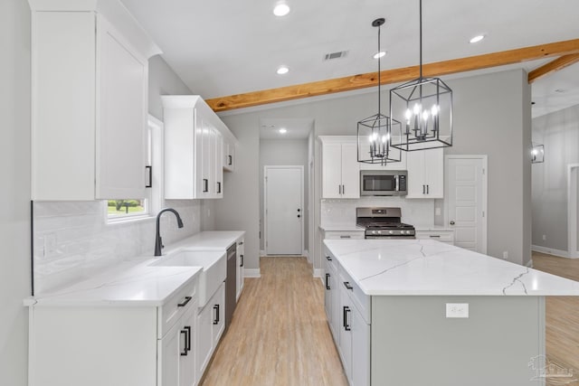 kitchen featuring decorative light fixtures, a center island, stainless steel appliances, beam ceiling, and white cabinets