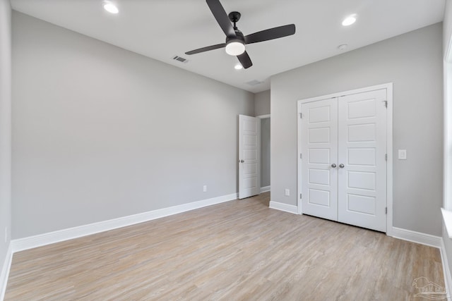 unfurnished bedroom with light hardwood / wood-style flooring, a closet, and ceiling fan