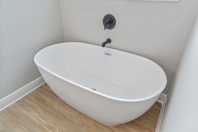 room details featuring hardwood / wood-style floors and a bathing tub