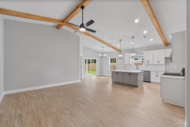 kitchen featuring pendant lighting, white cabinetry, dishwasher, a center island, and beam ceiling