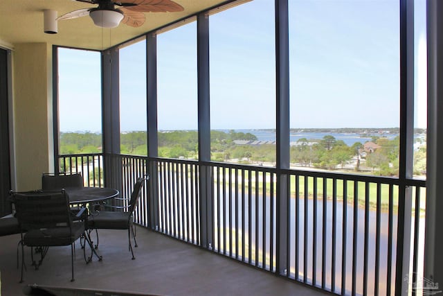 sunroom / solarium with a water view and ceiling fan