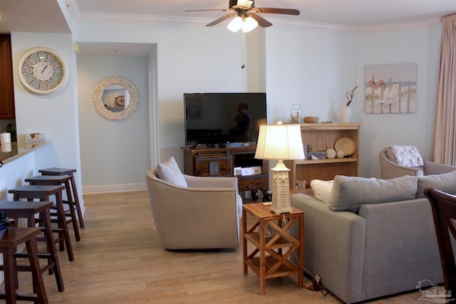 living room with light wood-type flooring, ceiling fan, and ornamental molding