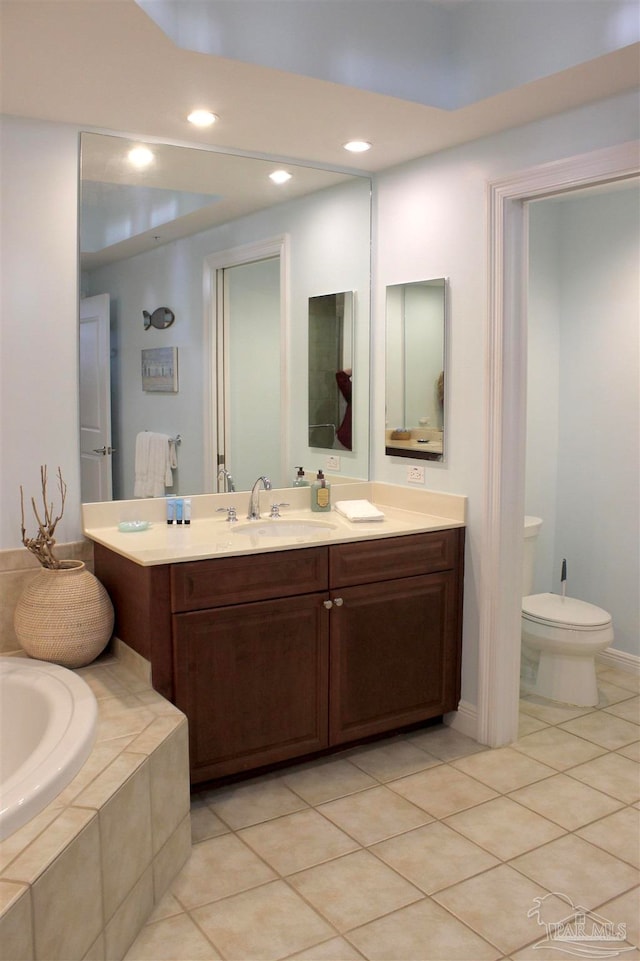 bathroom with vanity, tiled bath, tile patterned flooring, and toilet