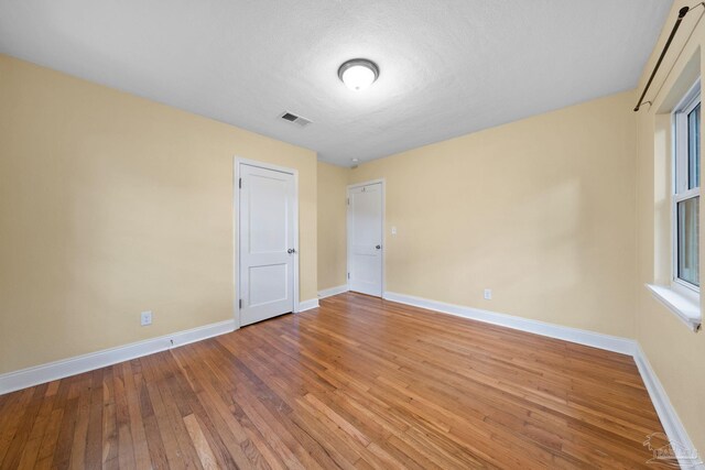 unfurnished living room featuring a chandelier and hardwood / wood-style floors