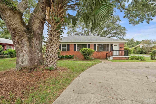 ranch-style home with brick siding and a front yard