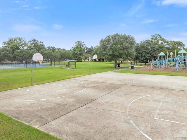 view of basketball court with a playground and a lawn