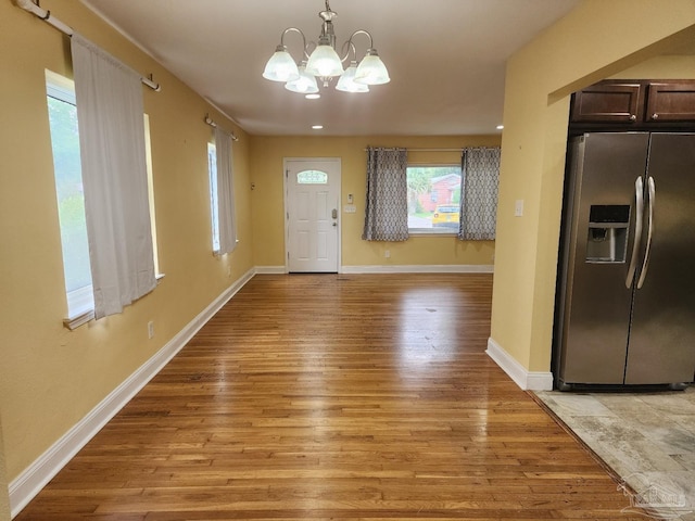 foyer entrance with a chandelier and light hardwood / wood-style flooring