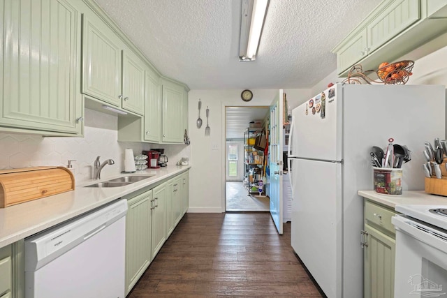 kitchen with white appliances, sink, a textured ceiling, green cabinets, and dark hardwood / wood-style floors