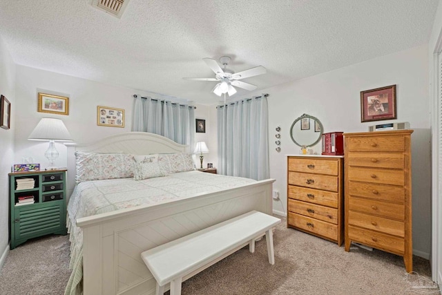 carpeted bedroom featuring a textured ceiling and ceiling fan