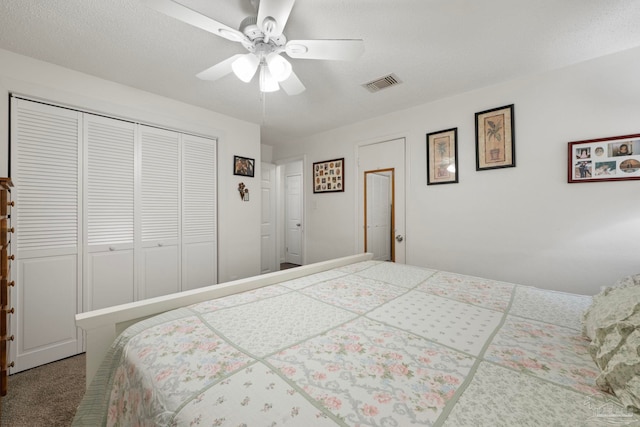 bedroom featuring a closet, a textured ceiling, carpet flooring, and ceiling fan