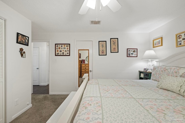 carpeted bedroom with ceiling fan and a textured ceiling