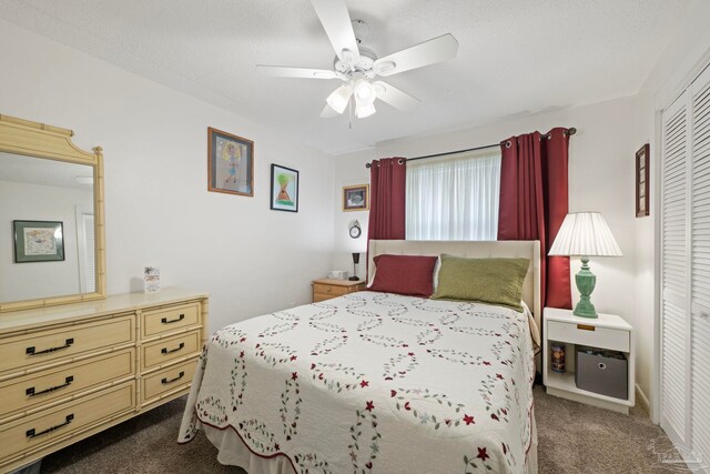 carpeted bedroom with a textured ceiling, a closet, and ceiling fan