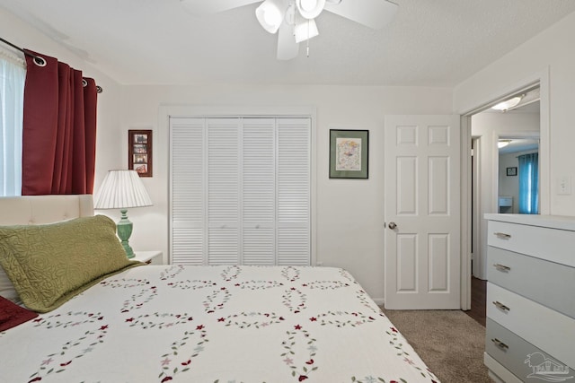 carpeted bedroom featuring a textured ceiling, a closet, and ceiling fan