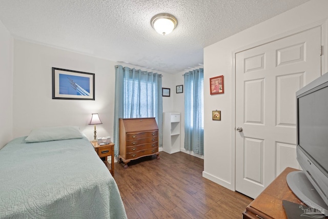 bedroom with a textured ceiling and dark wood-type flooring