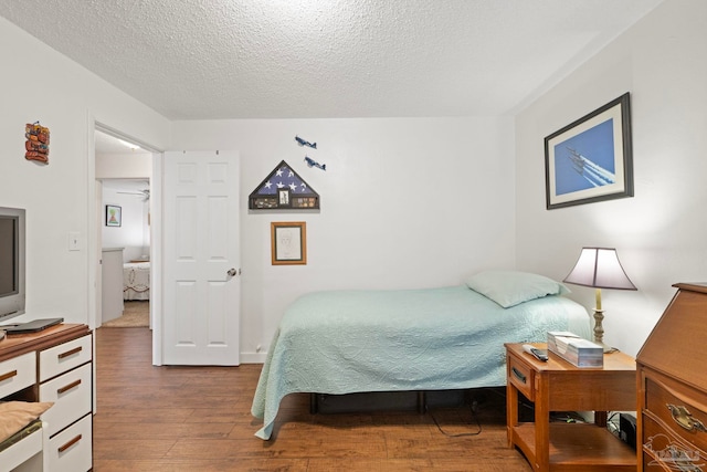 bedroom featuring wood-type flooring and a textured ceiling