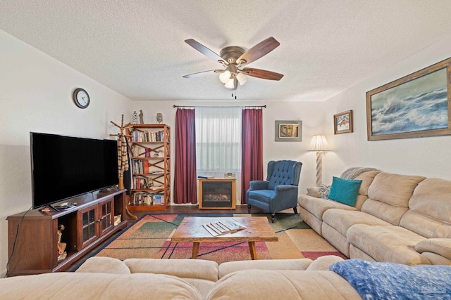 living room with ceiling fan, a textured ceiling, and light hardwood / wood-style flooring