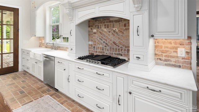 kitchen with white cabinetry, stainless steel appliances, sink, and backsplash