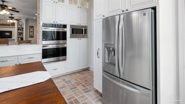 kitchen with white cabinetry, stainless steel appliances, and ceiling fan