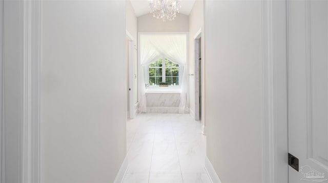 hallway featuring lofted ceiling, light tile patterned floors, and a notable chandelier