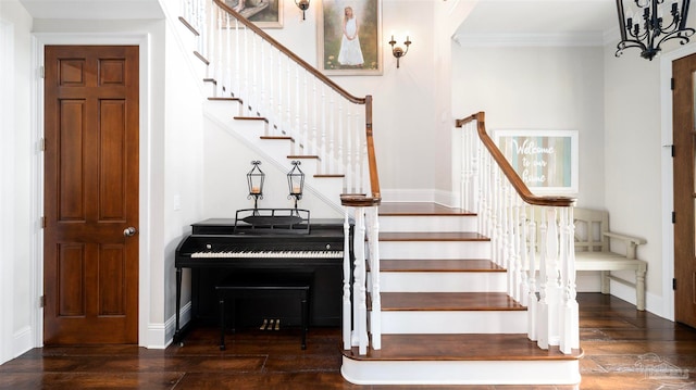 stairs with wood-type flooring, a notable chandelier, and ornamental molding