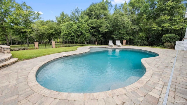 view of pool featuring a lawn and a patio