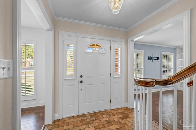 foyer featuring ornamental molding and a chandelier