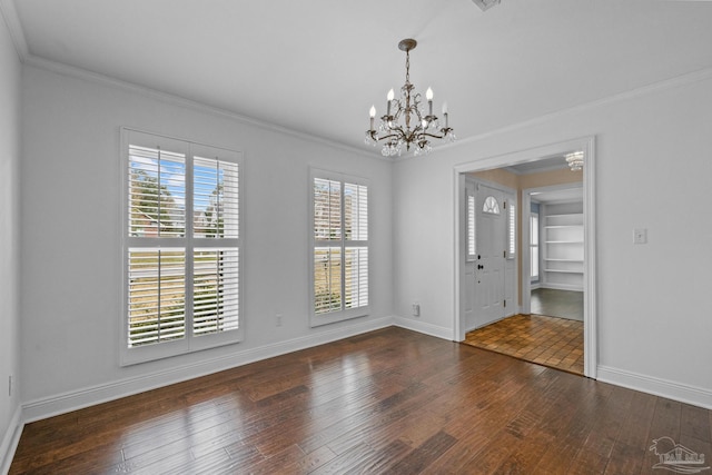 spare room with ornamental molding, dark hardwood / wood-style floors, and a notable chandelier