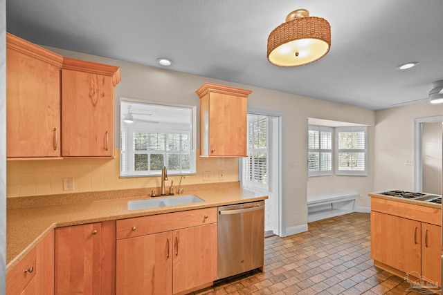 kitchen with light brown cabinetry, sink, stainless steel dishwasher, ceiling fan, and gas stovetop