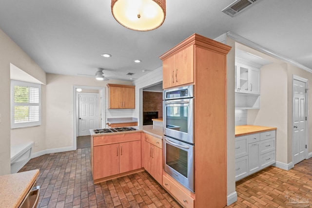 kitchen with ceiling fan, stainless steel appliances, white cabinets, kitchen peninsula, and light brown cabinets