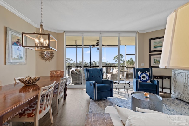 living room featuring ceiling fan with notable chandelier, hardwood / wood-style floors, a textured ceiling, expansive windows, and crown molding