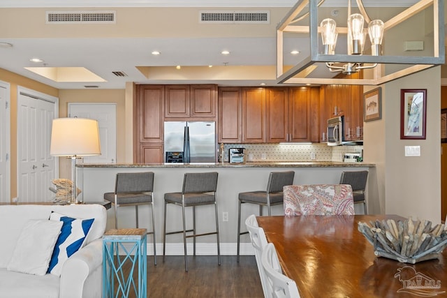 kitchen with an inviting chandelier, appliances with stainless steel finishes, decorative backsplash, dark hardwood / wood-style floors, and decorative light fixtures