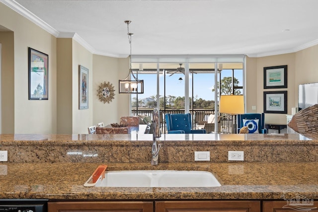 kitchen featuring an inviting chandelier, ornamental molding, sink, and decorative light fixtures