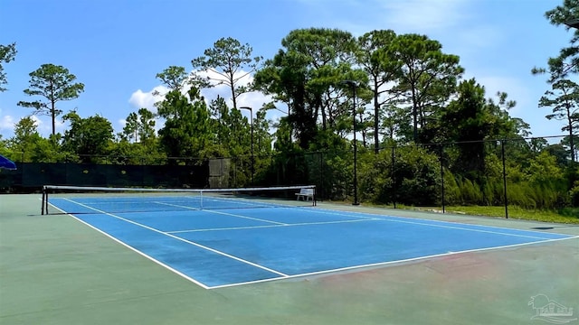 view of tennis court with basketball hoop