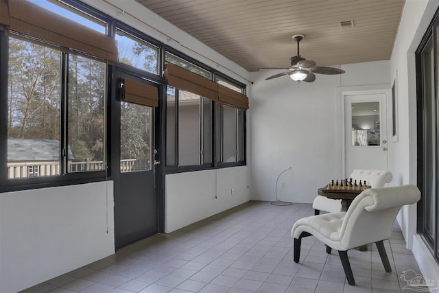 sunroom featuring wooden ceiling and ceiling fan