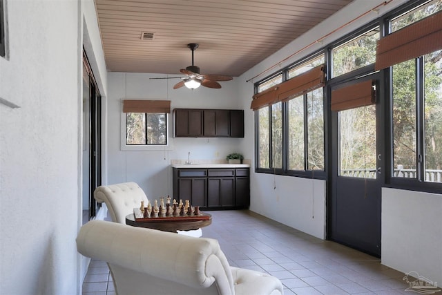 sunroom / solarium featuring ceiling fan, a healthy amount of sunlight, and wooden ceiling