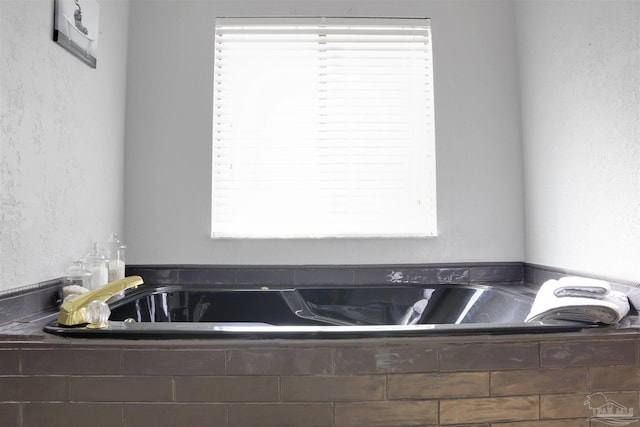 bathroom featuring tiled tub