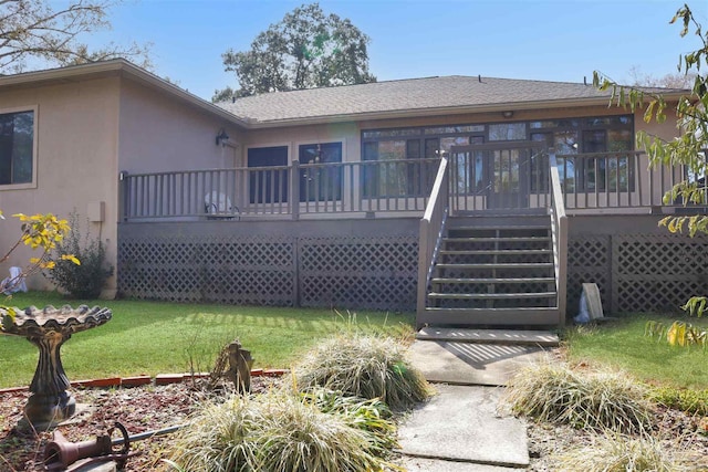 rear view of property with a wooden deck, a yard, and a sunroom