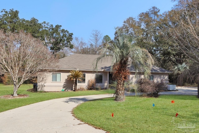 ranch-style home with a front yard and central AC unit