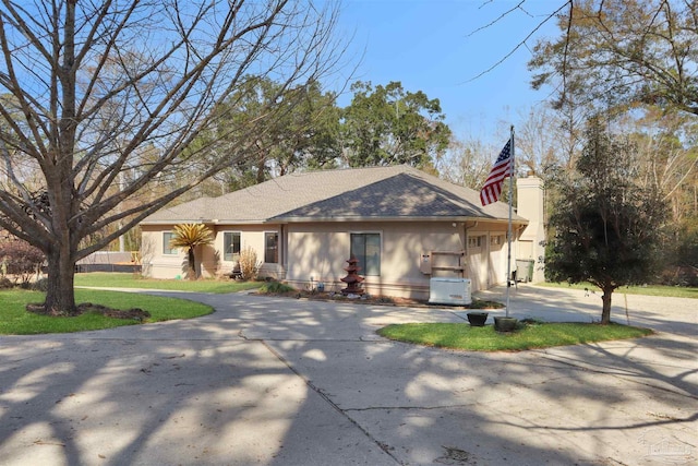 ranch-style home featuring a garage and a front lawn