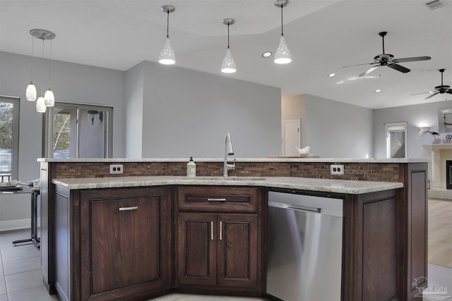 kitchen featuring dishwasher, sink, hanging light fixtures, dark brown cabinets, and a center island with sink