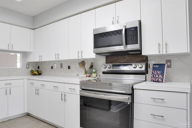 kitchen with stainless steel appliances, white cabinets, and decorative backsplash