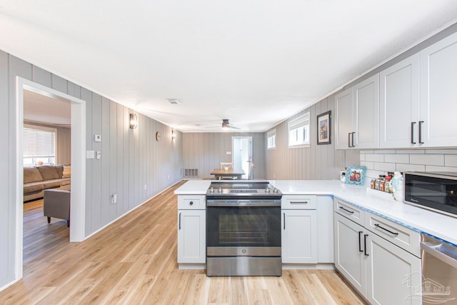 kitchen with kitchen peninsula, light wood-type flooring, and appliances with stainless steel finishes