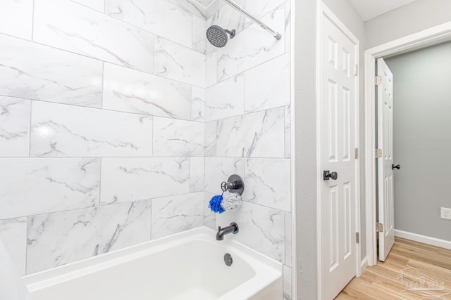 bathroom featuring tiled shower / bath combo and hardwood / wood-style flooring