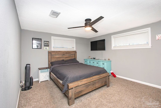 bedroom with ceiling fan, carpet floors, and a textured ceiling