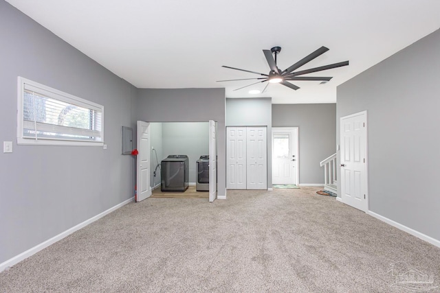 unfurnished bedroom featuring carpet flooring, washing machine and dryer, two closets, and ceiling fan