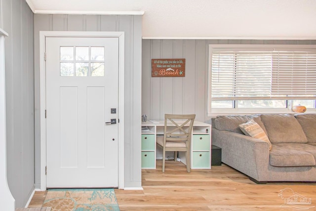 entrance foyer with wooden walls, hardwood / wood-style flooring, and ornamental molding