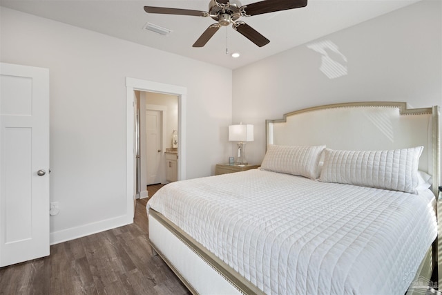 bedroom featuring connected bathroom, dark hardwood / wood-style floors, and ceiling fan