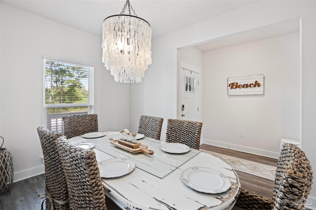 dining space with dark hardwood / wood-style floors and an inviting chandelier