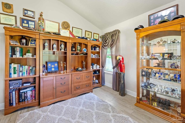 misc room with light hardwood / wood-style flooring and lofted ceiling